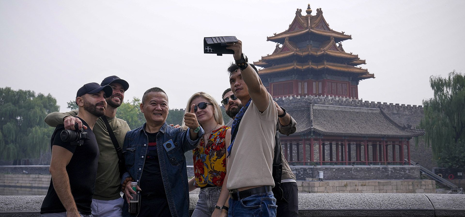 Turistas extranjeros se toman una selfie con un hombre chino cerca de una torre de la Ciudad Prohibida en Beijing, el martes 26 de septiembre de 2023. (Foto AP/Andy Wong) Turistas extranjeros se toman una selfie con un hombre chino cerca de una torre de la Ciudad Prohibida en Beijing, el martes 26 de septiembre de 2023. (Foto AP/Andy Wong)