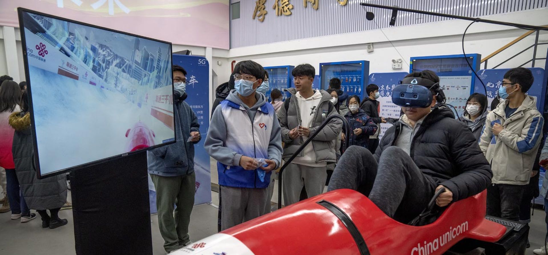 Un estudiante prueba un simulador de bobsleigh de realidad virtual durante un evento en la Universidad de Correos y Comunicaciones de Beijing, el jueves 9 de diciembre de 2021. Los organizadores olímpicos chinos celebraron el jueves uno de los primeros eventos públicos en mostrar la llama olímpica desde su llegada de Grecia en octubre como parte de la preparación para los Juegos Olímpicos de Invierno de 2022 en febrero.