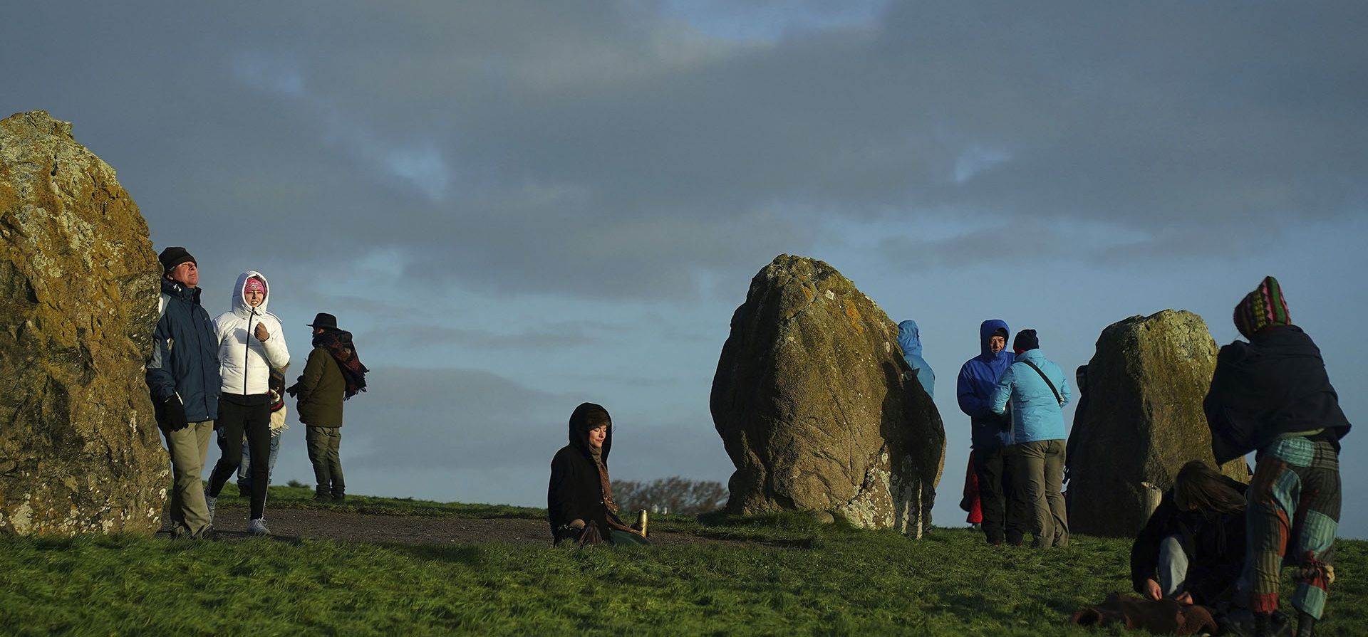Gente reunida en Newgrange, en la mañana del solsticio de invierno, que está marcada por celebraciones paganas. en Co. Meath, Irlanda, el miércoles 21 de diciembre de 2022. Newgrange es un monumento prehistórico, que se cree que fue construido por el Neolítico hace 5.000 años para que el sol brillara sobre las cenizas de sus muertos en la tumba, lo que representa un signo de renacimiento (Brian Lawless/PA vía AP)