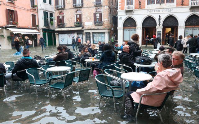 Los turistas y residentes reanudan su rutina normal en un bar luego de que las mareas altas regresaran y la ciudad experimentara su peor inundación en más de 50 años, noviembre de 2019.