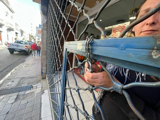 Un comerciante cierra con cadena y candado su negocio este martes en Córdoba.