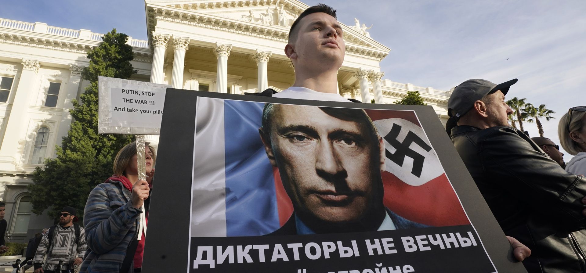 Un joven sostiene una pancarta para protestar por la invasión rusa de Ucrania durante un mitin en el Capitolio en Sacramento, California. Foto: AP