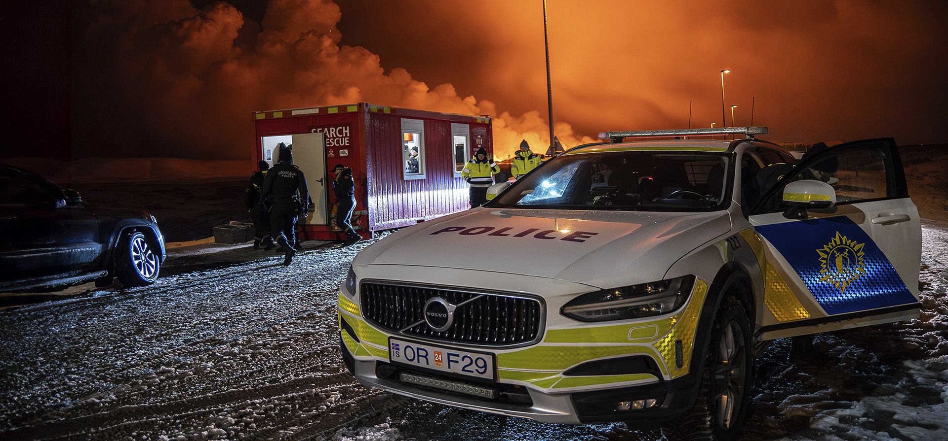 Un vehículo policial vigila la entrada de la carretera a Grindavík con la erupción en el fondo, cerca de Grindavik en la península de Reykjanes de Islandia, el lunes 18 de diciembre de 2023. Una erupción volcánica comenzó el lunes por la noche en la península de Reykjanes de Islandia, volviendo el cielo naranja y provocar que la defensa civil del país esté en alerta máxima. (AP Photo/Marco Di Marco) Un vehículo policial vigila la entrada de la carretera a Grindavík con la erupción en el fondo, cerca de Grindavik en la península de Reykjanes de Islandia, el lunes 18 de diciembre de 2023. Una erupción volcánica comenzó el lunes por la noche en la península de Reykjanes de Islandia, volviendo el cielo naranja y provocar que la defensa civil del país esté en alerta máxima. (AP Photo/Marco Di Marco)