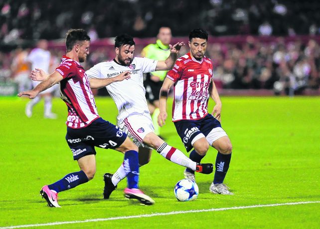 Rodeado. José San Román intenta pasar entre dos jugadores de Unión