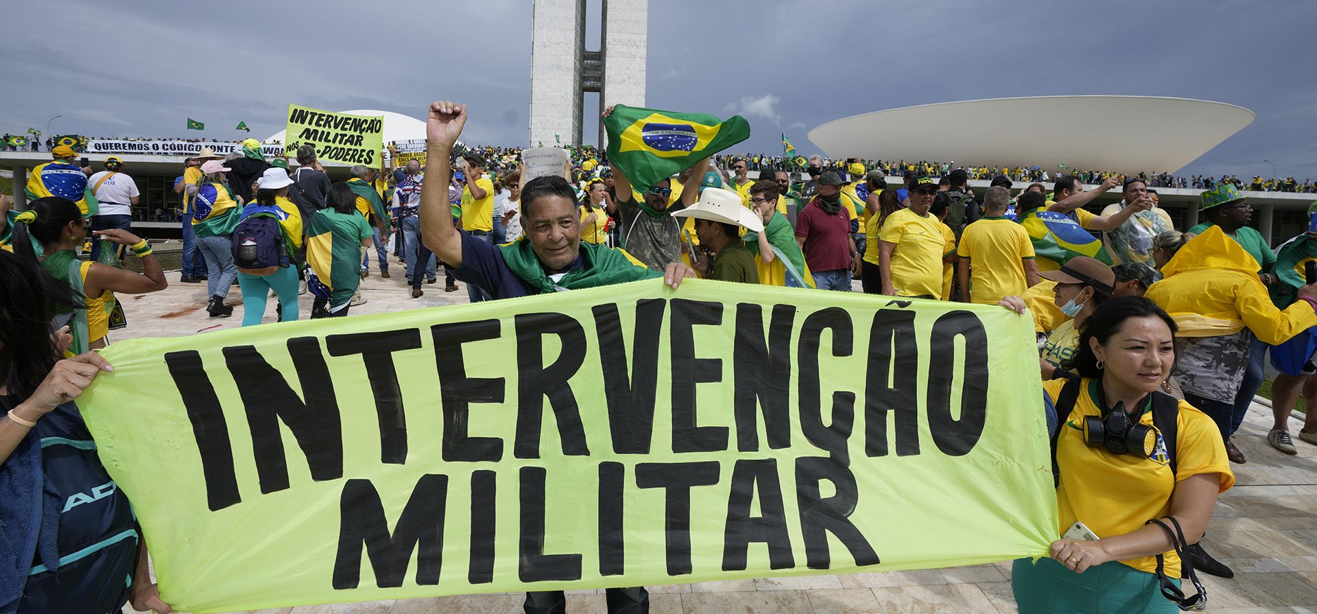 Manifestantes, simpatizantes del expresidente brasileño Jair Bolsonaro, sostienen una pancarta que dice en portugués 