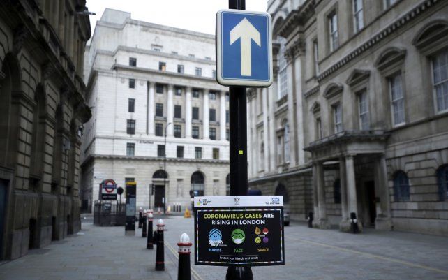 Un letrero de advertencia de seguridad contra el coronavirus se exhibe en el distrito financiero de la ciudad de Londres.