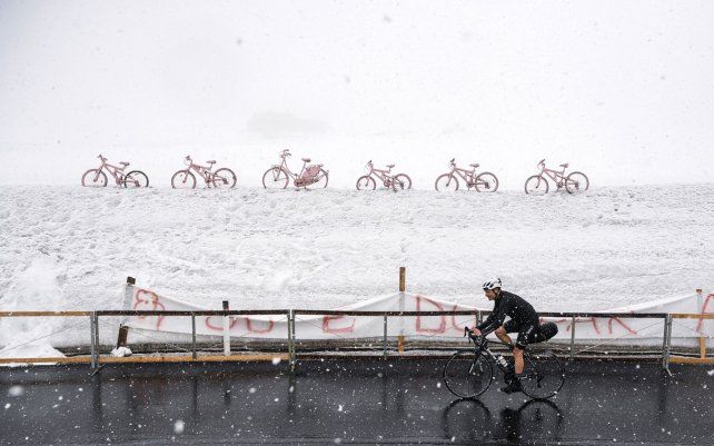 Un ciclista en solitario pedalea bajo la nieve en las montañas Dolomitas Giau Pass, parte de la 16° etapa de la carrera ciclista Giro d