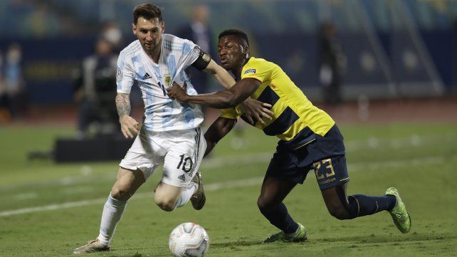 Lio y el ecuatoriano Moisés Caicedo luchan por el balón. AP Photo / Andre Penner