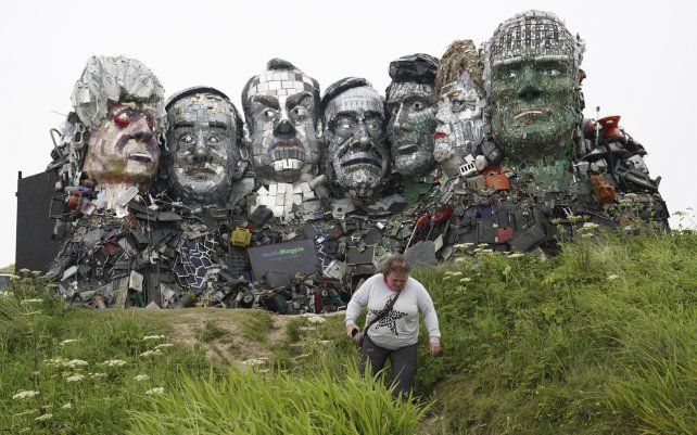 Un visitante pasa junto a una escultura creada a partir de desechos electrónicos a semejanza del monte Rushmore y los líderes del G7 en una colina en Hayle, Cornwall, Inglaterra.