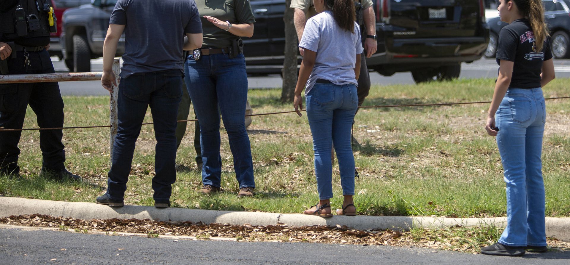 Un oficial de la ley habla con personas fuera de la Escuela Secundaria Uvalde después de que se informó de un tiroteo más temprano en el día en la Escuela Primaria Robb, el martes 24 de mayo de 2022, en Uvalde, Texas.