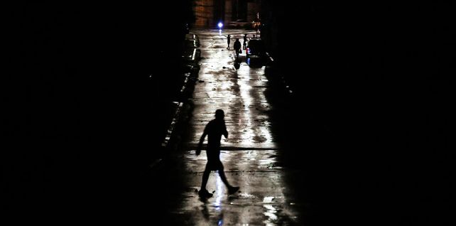 La gente camina por una calle oscura durante un apagón causado por el huracán Rafael, La Habana, Cuba. Fotografía: Yamil Lage/AFP/Getty Images