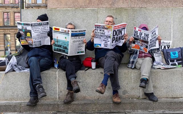 Manifestantes climáticos utilizan la prensa para burlarse de los líderes mundiales durante la COP26 en Glasgow, Gran Bretaña.