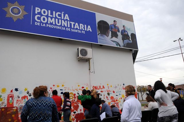 Agentes de la Policía Comunitaria junto a chicos y vecinos realizando el mural.