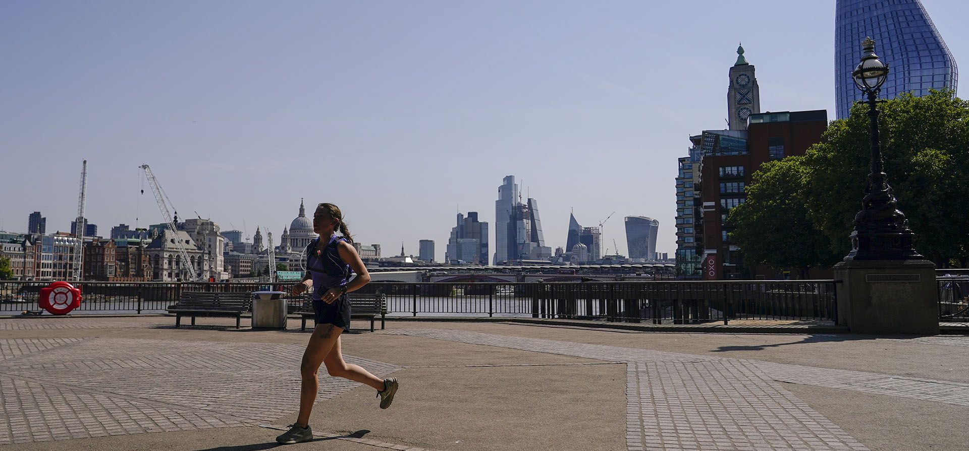 Una mujer corre en la orilla sur del río Támesis, en Londres, el lunes 18 de julio de 2022. La primera advertencia de calor extremo de Gran Bretaña está vigente para gran parte de Inglaterra debido al clima cálido y seco que ha quemado Europa continental durante la última semana.