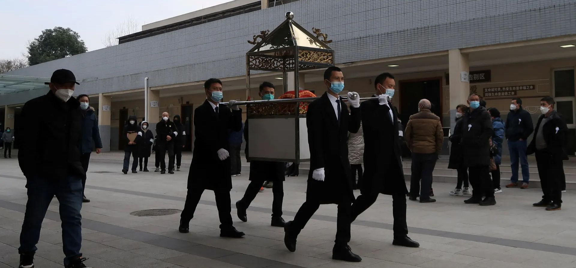 Chengdu, China. Miembros del personal funerario llevan una urna en parte de una procesión fuera de un crematorio en medio del brote de Covid en la provincia de Sichuan. Fotografía: Reuters