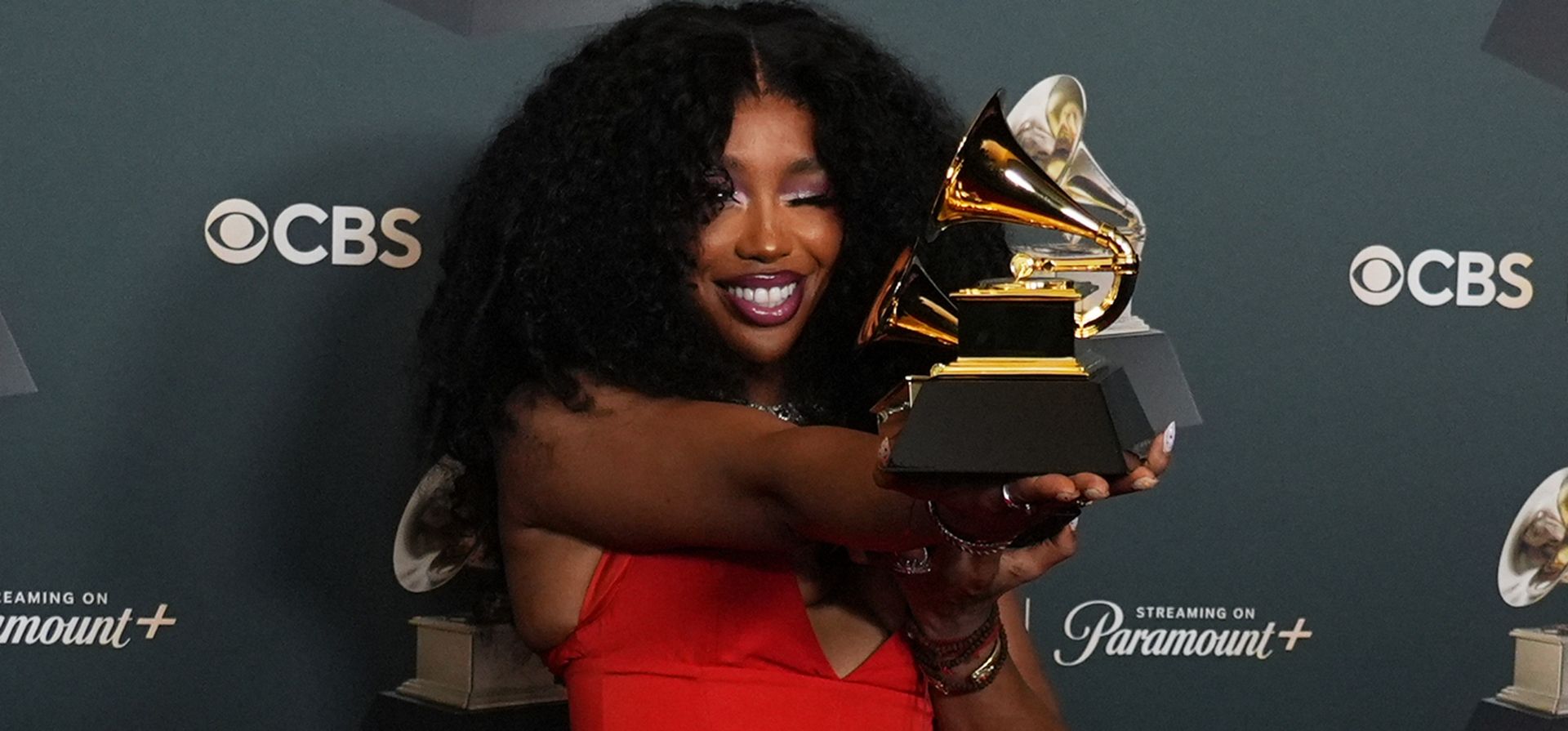 SZA posa en la sala de prensa con los premios a la grabación del año y a la mejor interpretación de rap melódico por 
