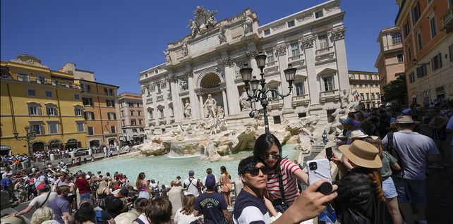 Turistas se toman una selfie frente a la Fontana de Trevi