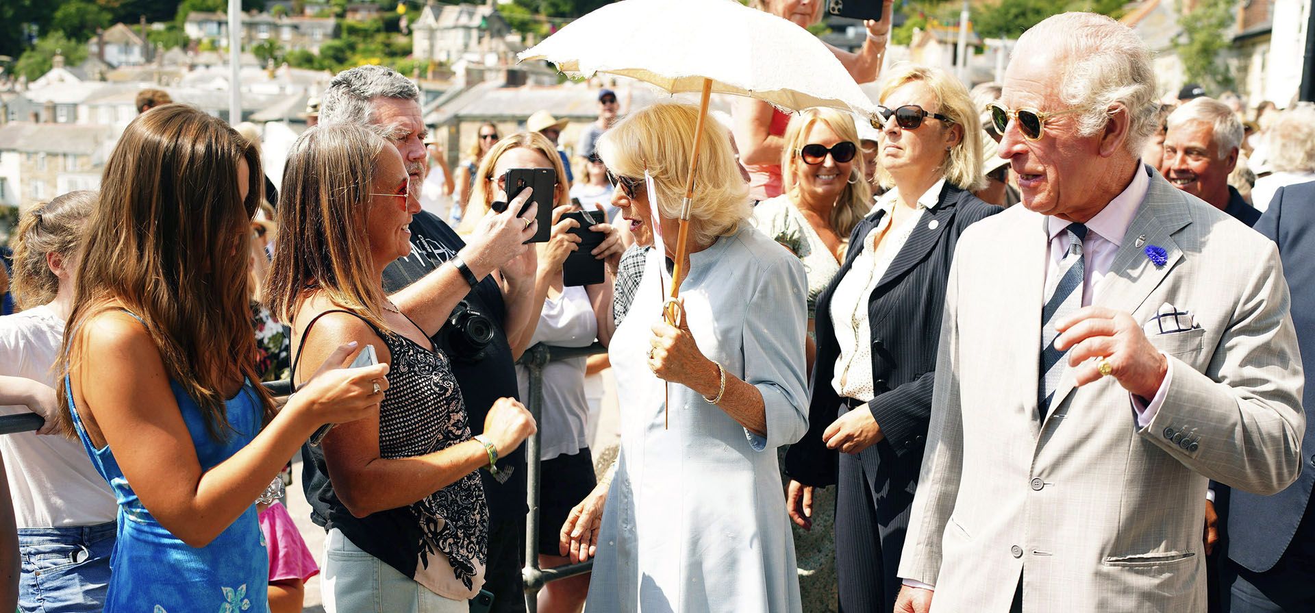 El príncipe Carlos de Gran Bretaña, en el centro a la izquierda, y Camilla, duquesa de Cornualles, se reúnen con los lugareños durante una visita al pueblo pesquero de Mousehole en el primer día de su visita anual al suroeste, en Penzance, Cornualles, Inglaterra, el lunes 18 de julio de 2019. 2022