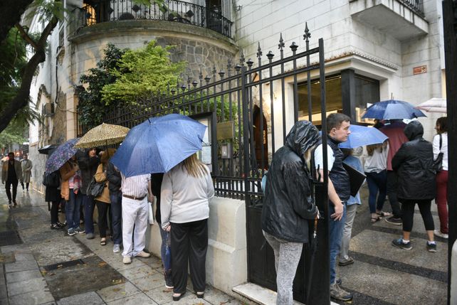 Bajo la lluvia. El público espera ingresar al Consulado de Italia para realizar gestiones sobre ciudadanía.