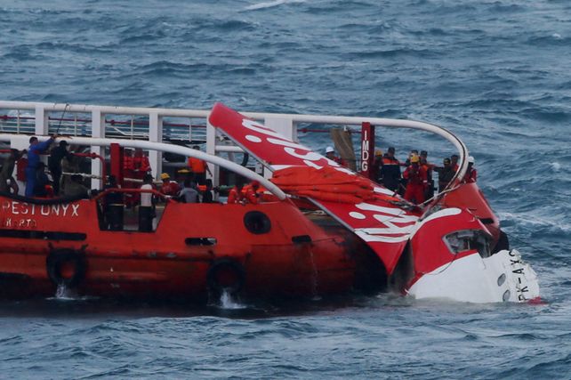 Rescatistas y marinos de Indonesia durante el rescate la cola del avión de Air Asia. (Foto: Reuters)