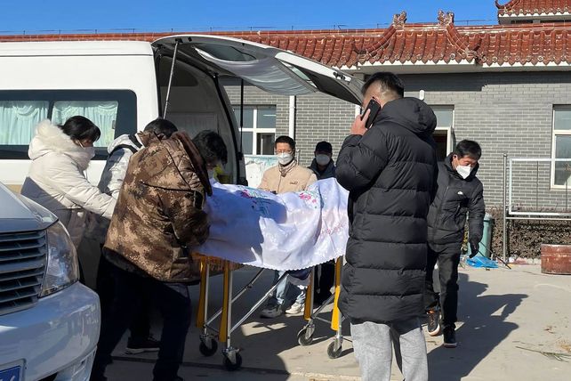 Familiares reciben el cuerpo de una anciana de 82 años en el patio de una casa fúnebre de Beijing.&nbsp;
