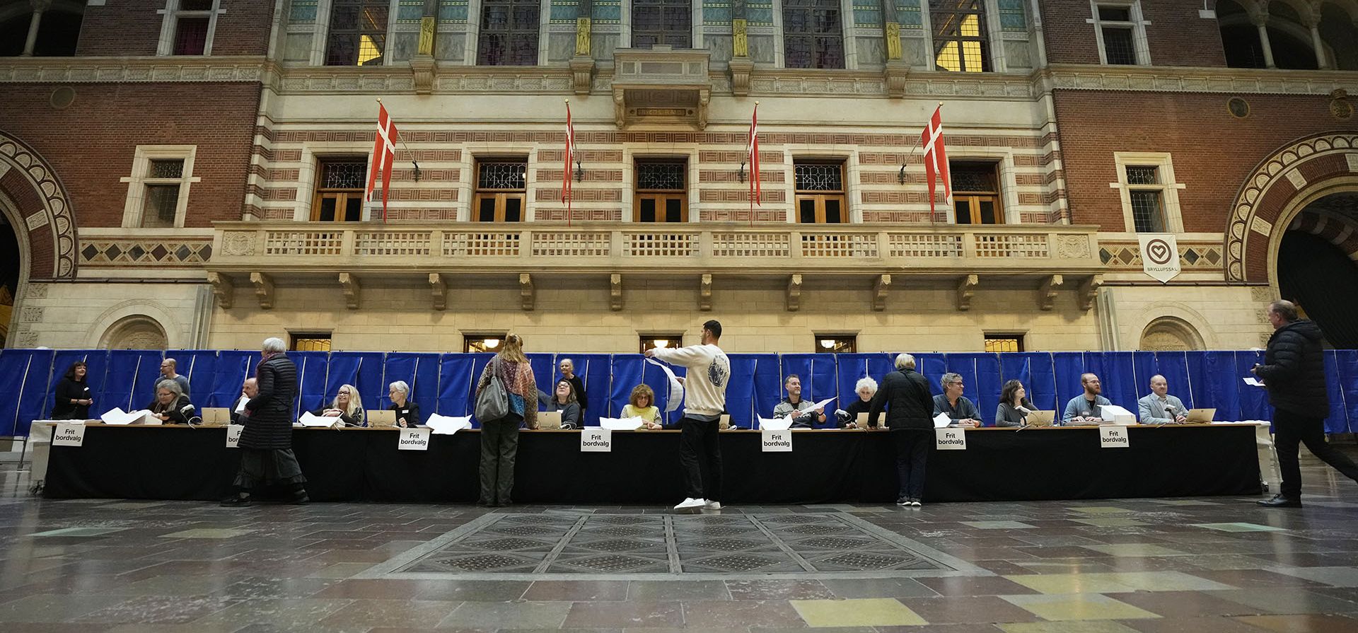 Votantes reciben boletas para emitir el sufragio en una mesa electoral en el Ayuntamiento de Copenhague, Dinamarca, el martes 1 de noviembre de 2022. Se espera que las elecciones de Dinamarca el martes cambien su panorama político, con nuevos partidos que esperan ingresar al parlamento y otros viendo cómo disminuye su apoyo.