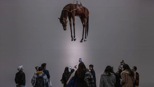 Visitantes observan algunas de las obras de la exposición Maurizio Cattelan: El último juicio