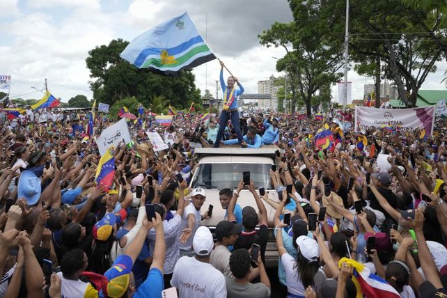 La opositora María Corina Machado ondea una bandera durante un acto de campaña del candidato presidencial Edmundo González Urrutia