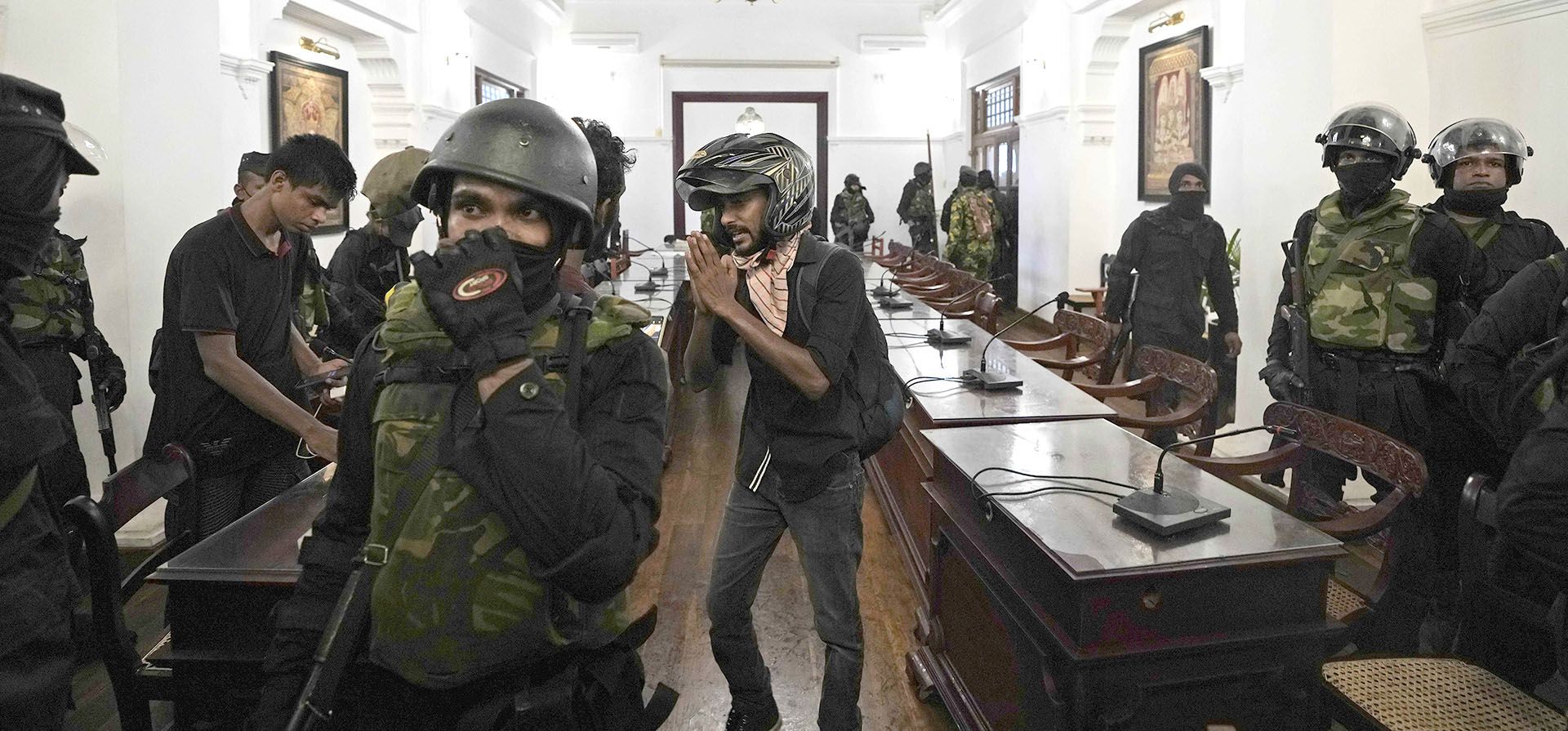 Soldados del ejército de Sri Lanka intentan sacar a los manifestantes que irrumpieron en la oficina del primer ministro Ranil Wickremesinghe y exigieron su renuncia después de que el presidente Gotabaya Rajapaksa huyó del país en medio de la crisis económica en Colombo, Sri Lanka, el miércoles 13 de julio de 2022.