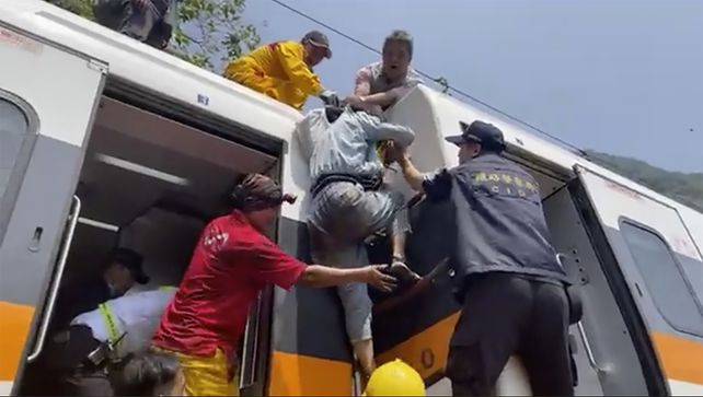 Los socorristas ayudan a una de las víctimas a salir del tres tras el violento impacto.