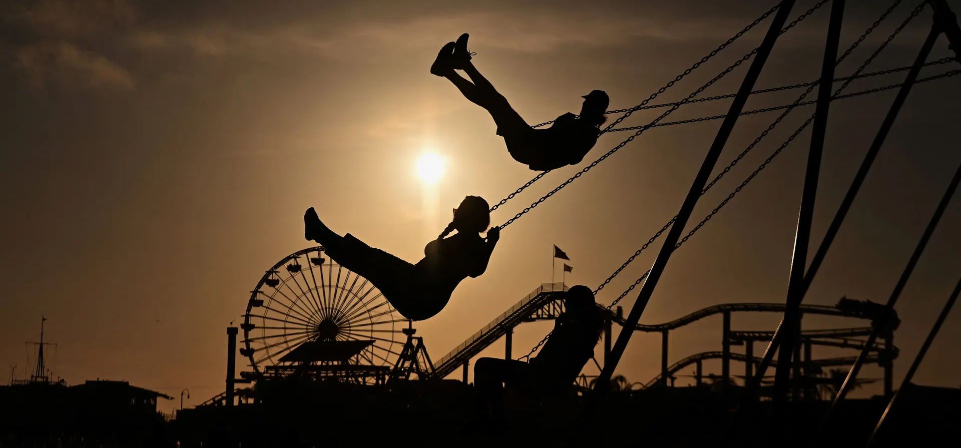 La gente monta columpios en la playa de la ciudad durante el atardecer, Santa Mónica, Estados Unidos. Fotografía: Angela Weiss/AFP/Getty Images