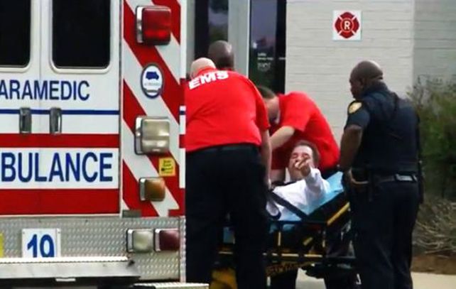 El frustrado ladrón de bancos es retirado en una ambulancia.