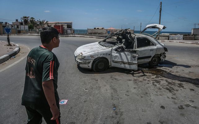 Un niño palestino observa un automóvil que fue alcanzado por un ataque aéreo israelí