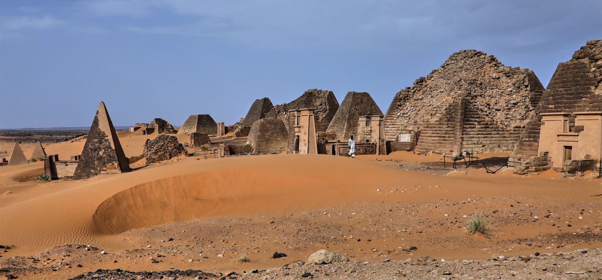 Un visitante camina entre las pirámides del yacimiento arqueológico de Meroe en Bejrawiya, Sudán. Fotografía: Mohnd Blal/AP Un visitante camina entre las pirámides del yacimiento arqueológico de Meroe en Bejrawiya, Sudán. Fotografía: Mohnd Blal/AP