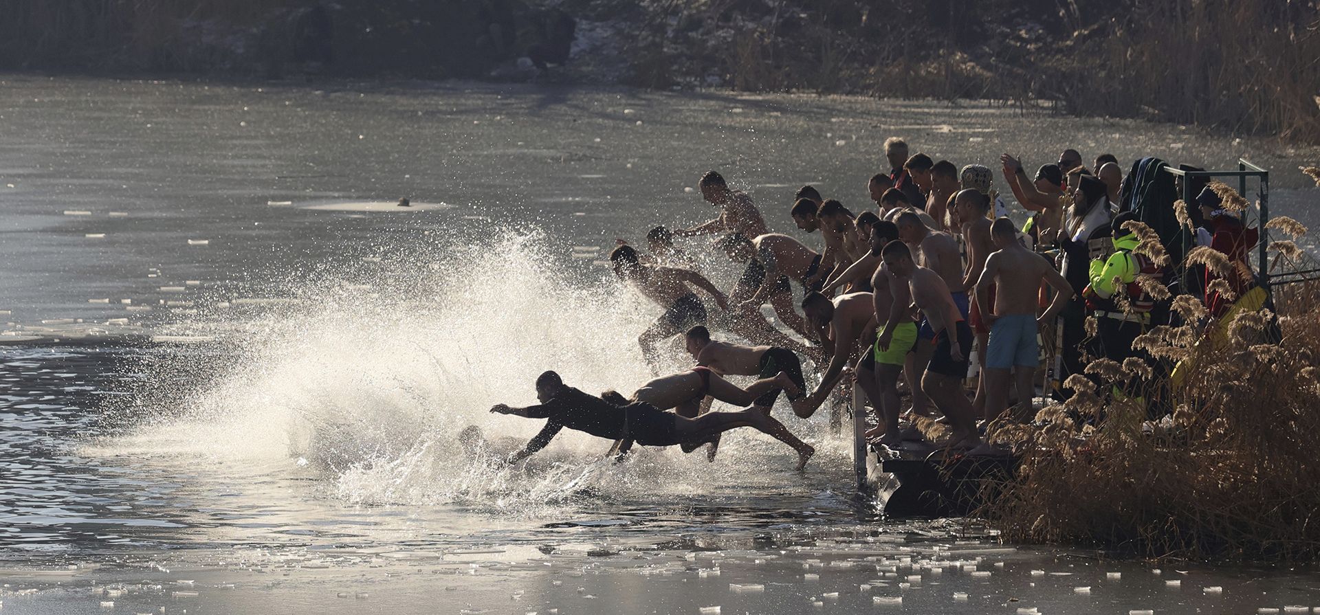 El patriarca búlgaro Danail arroja una cruz de madera al lago helado mientras los creyentes saltan para recuperarla, en Sofía, el lunes 6 de enero de 2025. (Foto AP/Valentina Petrova)