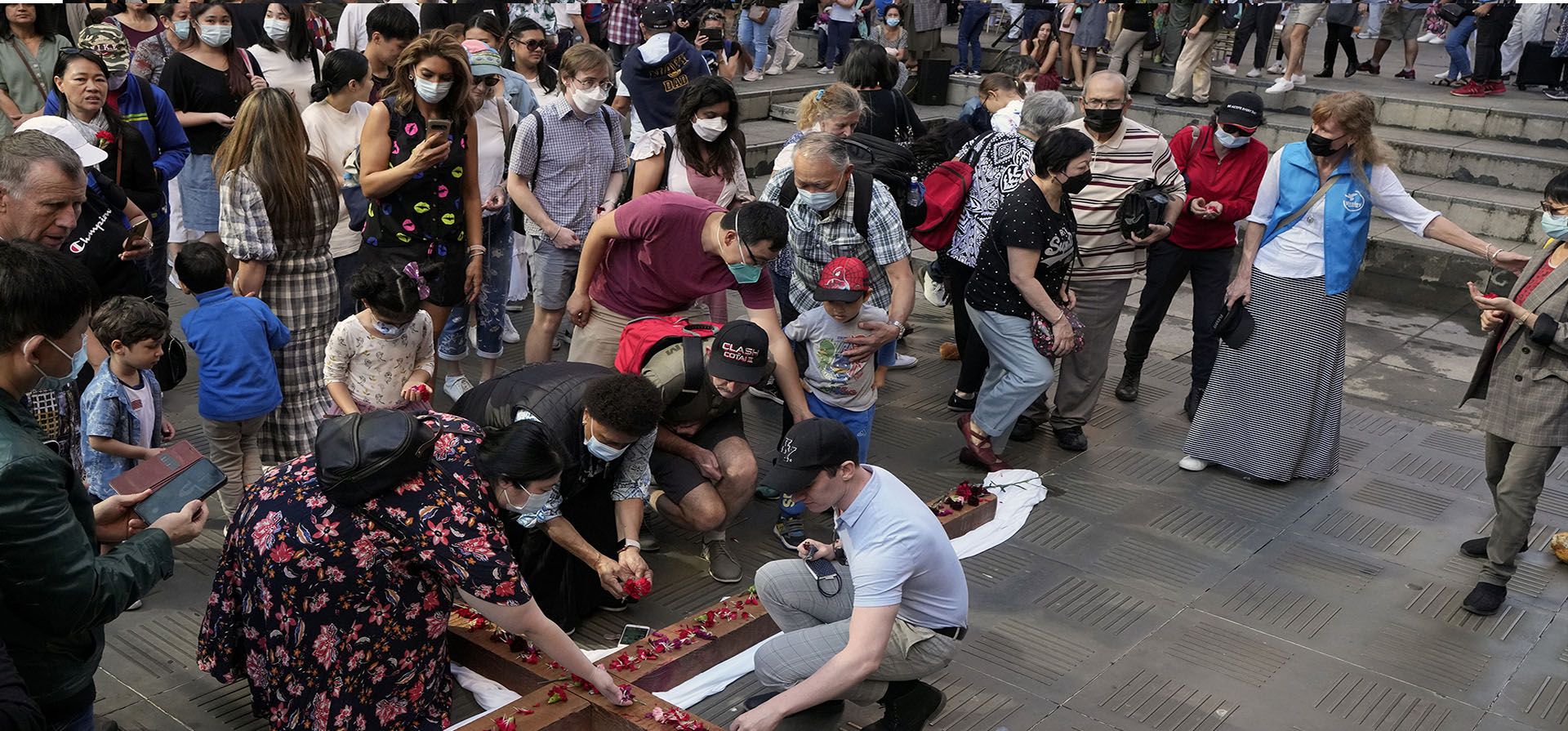 La gente deposita rosas en una cruz en un relato dramatizado de la crucifixión de Cristo durante las celebraciones del Viernes Santo en Sídney, el viernes 15 de abril de 2022.