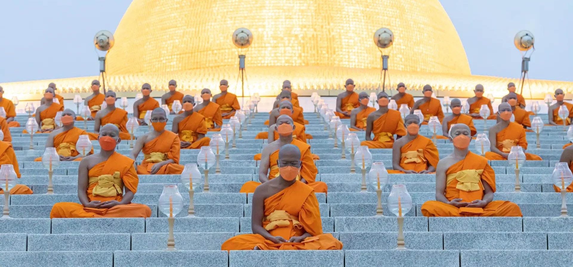 Homenaje al Buda mientras los monjes meditan alrededor del Dhammakaya Cetiya. Los monjes budistas de todo el mundo cantan y meditan juntos por la paz y la seguridad mundial en este momento, Pathum Thani, Tailandia.