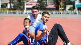 Yanina Martínez, el entrenador Martín Arroyo y Brian Impellizzeri posan para La Capital en la pista del estadio municipal Jorge Newbery.
