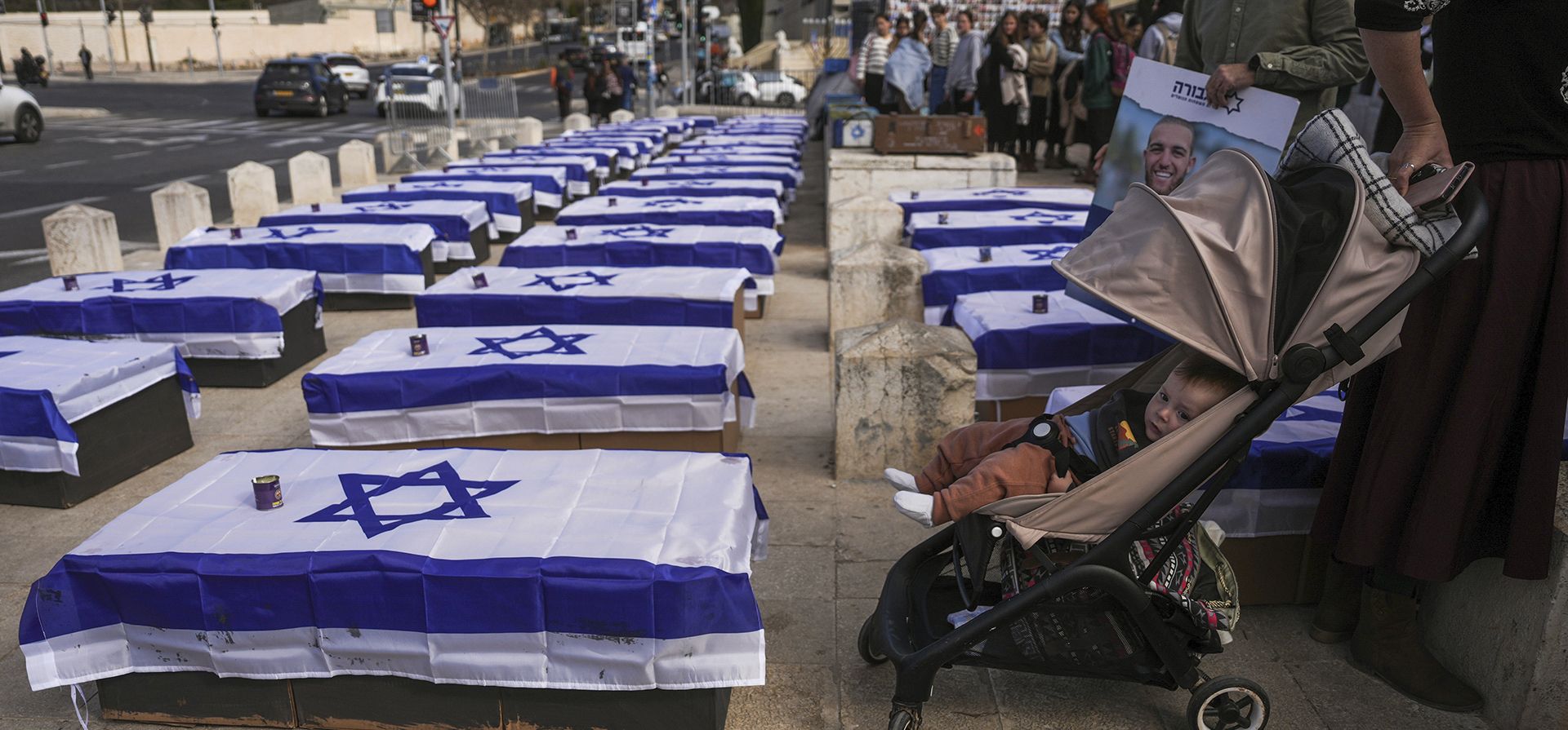 La gente se encuentra junto a ataúdes alineados en una calle y cubiertos con banderas israelíes que pretenden simbolizar el precio que Israel pagará por aceptar un alto el fuego con Hamas en una manifestación contra el acuerdo organizada por un grupo que representa a las familias de israelíes muertos durante la guerra en Gaza, en Jerusalén el jueves 16 de enero de 2025. (Foto AP/Ohad Zwigenberg) La gente se encuentra junto a ataúdes alineados en una calle y cubiertos con banderas israelíes que pretenden simbolizar el precio que Israel pagará por aceptar un alto el fuego con Hamas en una manifestación contra el acuerdo organizada por un grupo que representa a las familias de israelíes muertos durante la guerra en Gaza, en Jerusalén el jueves 16 de enero de 2025. (Foto AP/Ohad Zwigenberg)