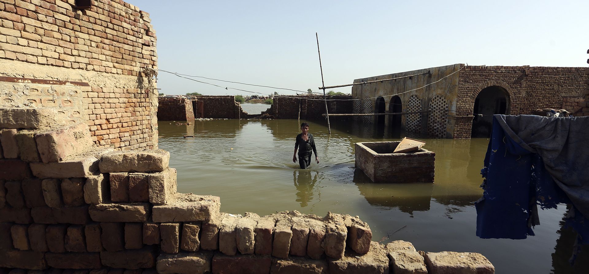 Un niño vadea a través de las inundaciones causadas por las lluvias monzónicas en Jaffarabad, Pakistán, el lunes 5 de septiembre de 2022. La agencia de refugiados de la ONU se apresuró el lunes a enviar más ayuda que se necesitaba desesperadamente a Pakistán asolado por las inundaciones mientras el primer ministro de la nación viajaba hacia el sur, donde el aumento de las aguas del lago Manchar suponen una nueva amenaza.
