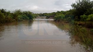 Susto. El hombre quiso pasar en moto por el arroyo crecido.