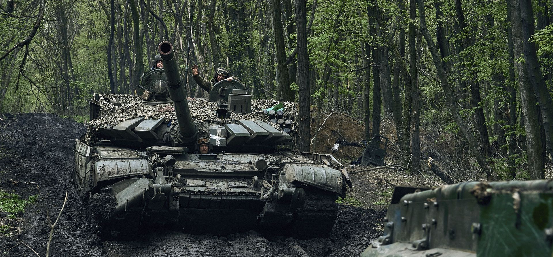 Soldados ucranianos saludan sobre un tanque que pasa en el frente en Bájmut, en la región de Donetsk, Ucrania, el domingo 23 de abril de 2023. (AP Foto/Libkos)