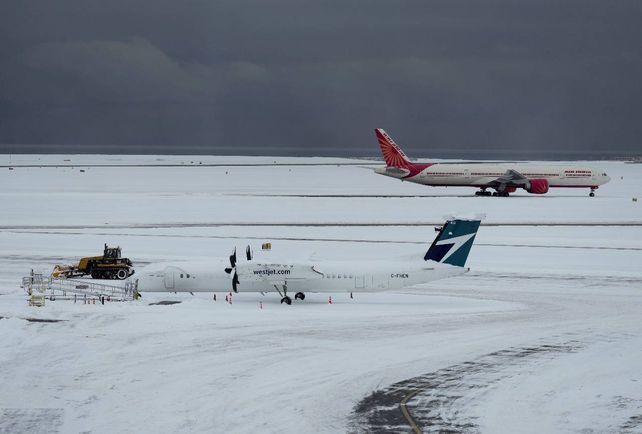 Aviones casi invisibles en la nieve en el aeropuerto de Vancouver
