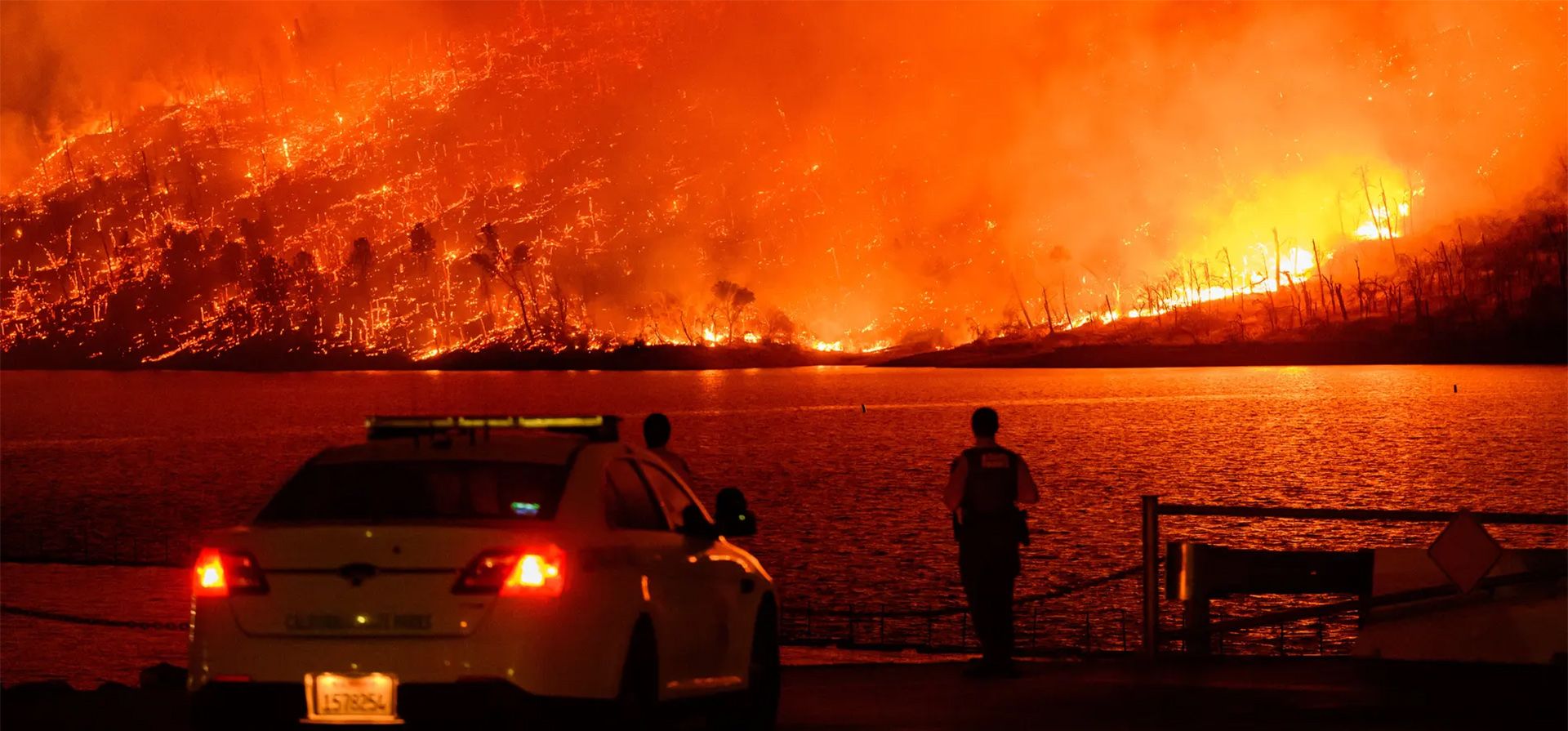 Los agentes de la ley observan cómo el incendio Thompson arde sobre el lago Oroville en Oroville. Una ola de calor está disparando las temperaturas, lo que ha provocado advertencias de incendio de bandera roja en todo el estado, California, Estados Unidos. Fotografía: Josh Edelson/AFP/Getty Images Los agentes de la ley observan cómo el incendio Thompson arde sobre el lago Oroville en Oroville. Una ola de calor está disparando las temperaturas, lo que ha provocado advertencias de incendio de bandera roja en todo el estado, California, Estados Unidos. Fotografía: Josh Edelson/AFP/Getty Images