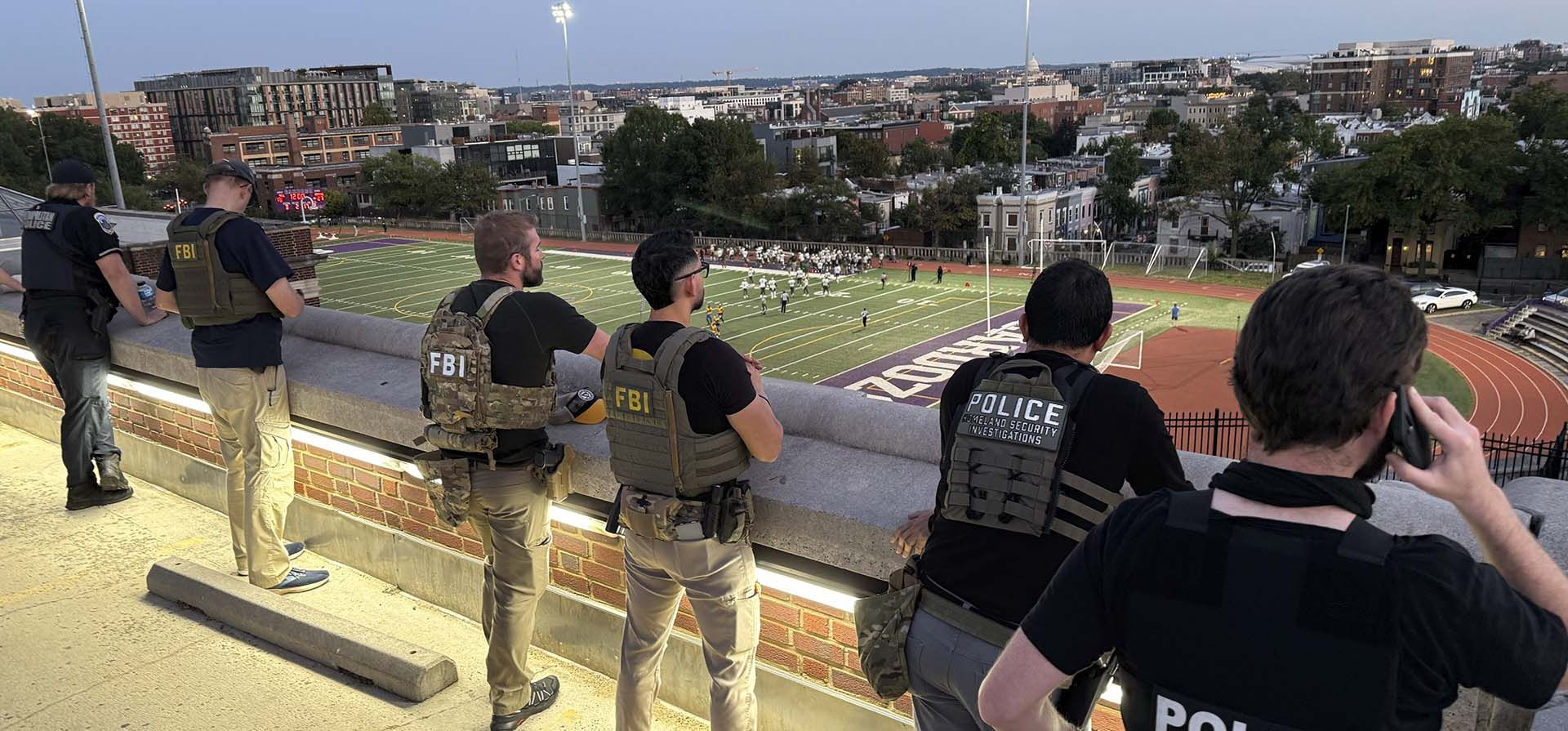 Oficiales del Departamento de Policía Metropolitana, el FBI y la Oficina de Investigaciones de Seguridad Nacional (HSI) monitorean un partido de fútbol americano entre Bell Multicultural y Archbishop Carroll, el viernes 12 de septiembre de 2025, en la escuela secundaria Cardozo, en el barrio de Columbia Heights, Washington. (Foto AP/Pablo Martínez Monsivais) Oficiales del Departamento de Policía Metropolitana, el FBI y la Oficina de Investigaciones de Seguridad Nacional (HSI) monitorean un partido de fútbol americano entre Bell Multicultural y Archbishop Carroll, el viernes 12 de septiembre de 2025, en la escuela secundaria Cardozo, en el barrio de Columbia Heights, Washington. (Foto AP/Pablo Martínez Monsivais)