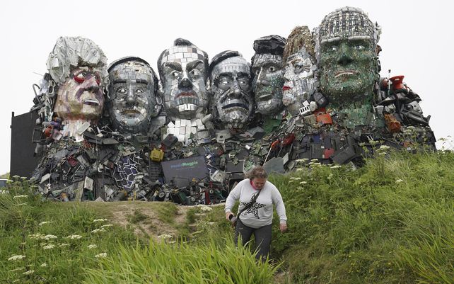 Un visitante pasa junto a una escultura creada a partir de desechos electrónicos a semejanza del monte Rushmore y los líderes del G7 en una colina en Hayle