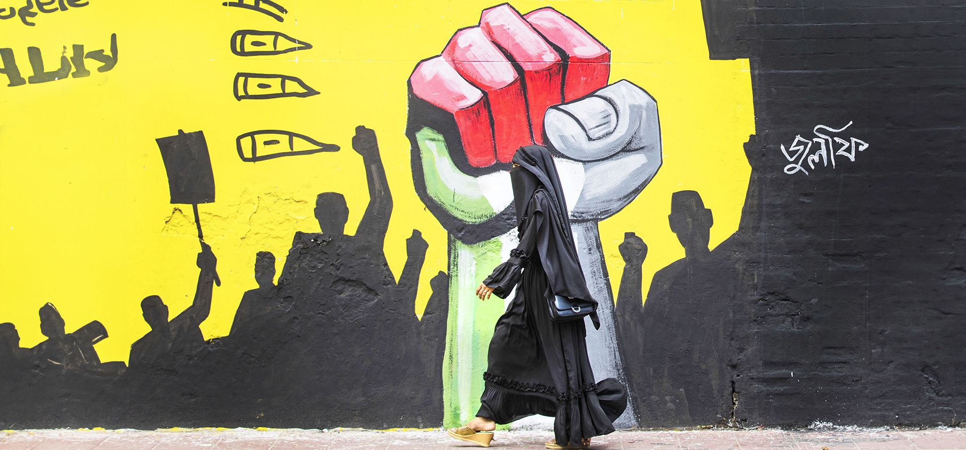 Una mujer camina junto a un grafiti en Dacca, Bangladesh, el viernes 9 de agosto de 2024. (Foto AP/Rajib Dhar) Una mujer camina junto a un grafiti en Dacca, Bangladesh, el viernes 9 de agosto de 2024. (Foto AP/Rajib Dhar)