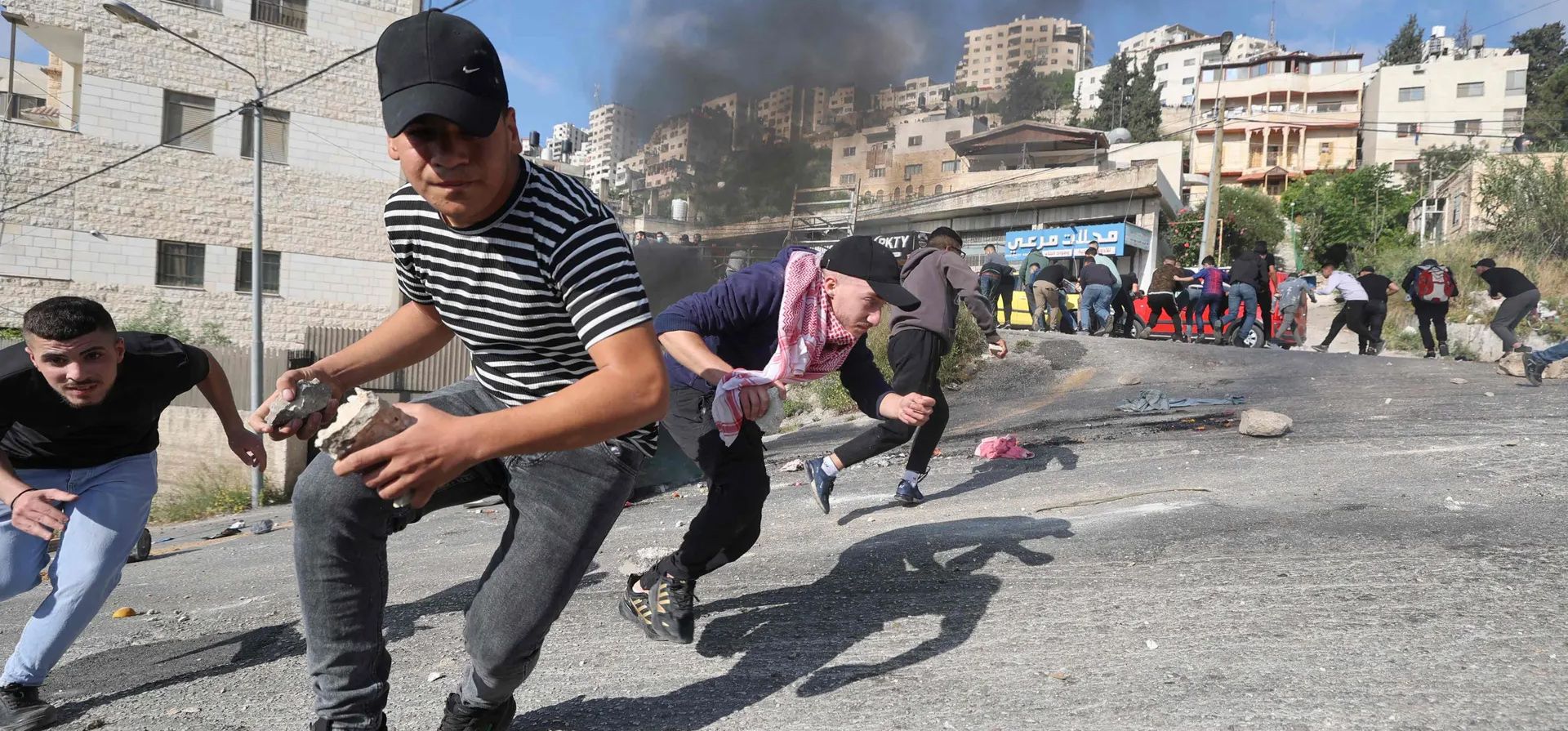 Manifestantes palestinos se cubren en medio de enfrentamientos con las fuerzas de seguridad israelíes durante una redada en la ciudad vieja. El ejército israelí dijo que sus tropas habían entrado en Nablus. La Sociedad de la Media Luna Roja Palestina dijo que sus médicos trataron 145 heridos, la mayoría por inhalación de gas lacrimógeno, mientras que una docena de personas recibieron disparos con fuego real. Fotografía: Jaafar Ashtiyeh/AFP/Getty Images