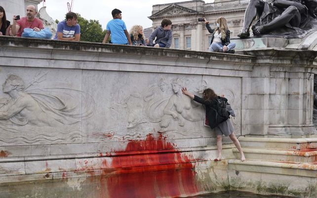 Manifestantes del grupo activista climática Extinction Rebellion embadurnan de pintura roja el Monumento a la Reina Victoria fuera de las puertas del Palacio de Buckingham en protesta contra la caza de animales