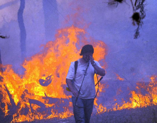 Vecinos de Villa Ciudad de América intentaron apagar el fuego por sus propios medios para que no pueda expandirse. (Foto: Télam)